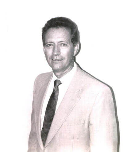 Jim-Frey Man in suit standing, looking confidently at camera.