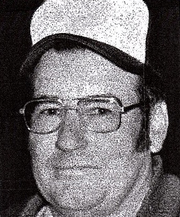 Man wearing glasses and a cap, looking forward.