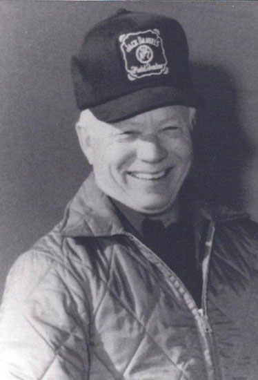 Smiling man in a cap and quilted jacket.