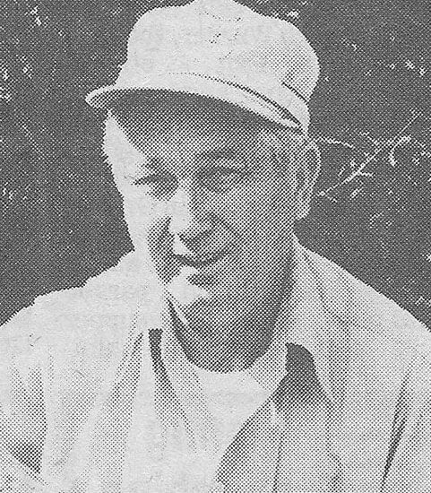Man wearing a cap, smiling outdoors.