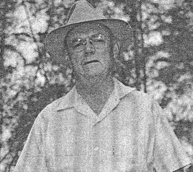 ewalt-john-william Man in hat standing outdoors with trees behind.