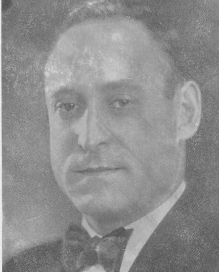 Man in formal attire, gazing forward solemnly.