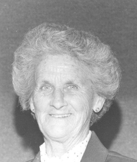 Smiling elderly woman with short, styled hair.