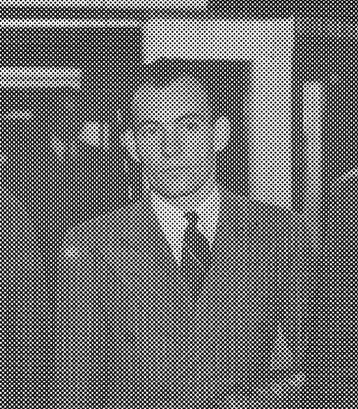 Man in suit, standing solemnly in grayscale photo.