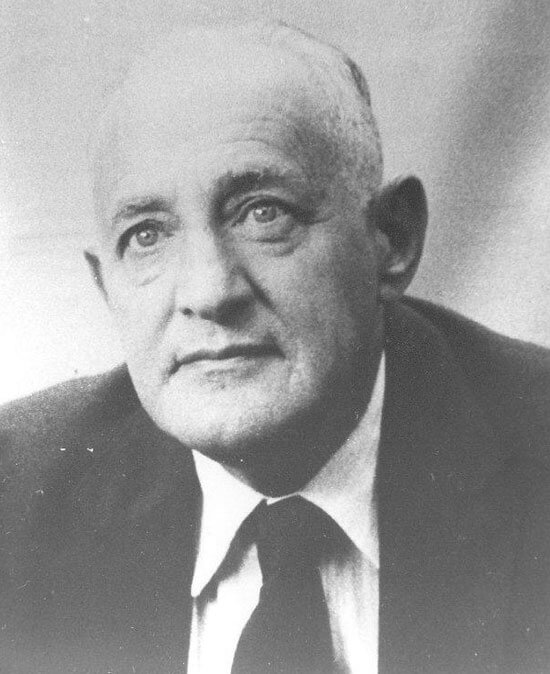 kulchinski-aaron Elderly man gazing thoughtfully, wearing suit and tie.