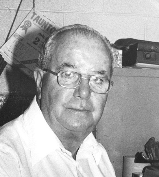 Man wearing glasses looks thoughtful in black and white.
