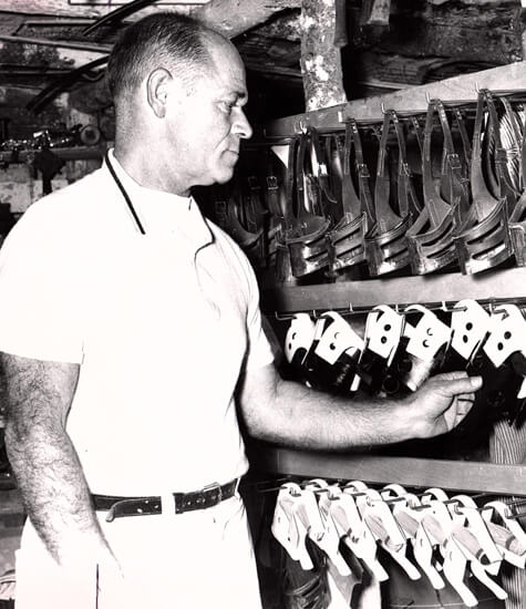 Man inspecting greyhound silks in a storeroom.