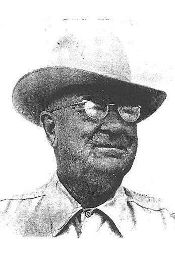 Man in hat gazing thoughtfully, wearing glasses.