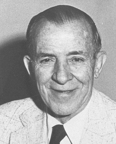 Smiling man in a suit, historic black-and-white photo.