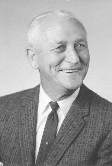 Smiling elderly man in a suit and tie.