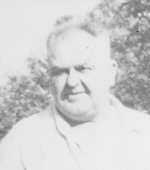 Man standing outdoors, face slightly blurred.