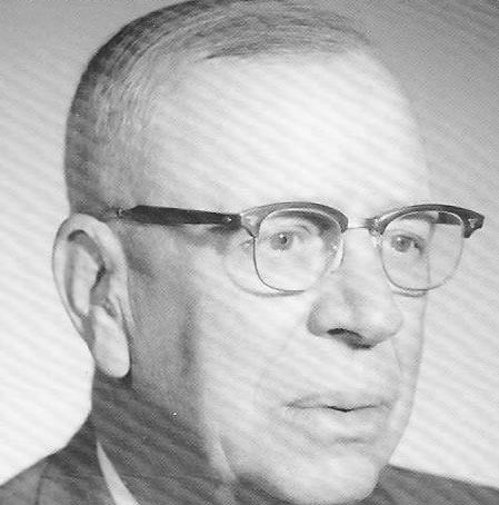 Man in glasses gazing thoughtfully to the side.